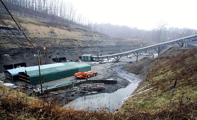 The entrance to the Sago Coal Mine. An above-ground conveyor belt and various types of mining machinery are visible.