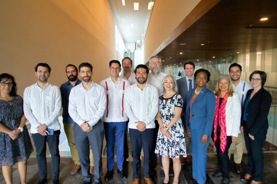 A group of 14 diverse people pose for a photo.