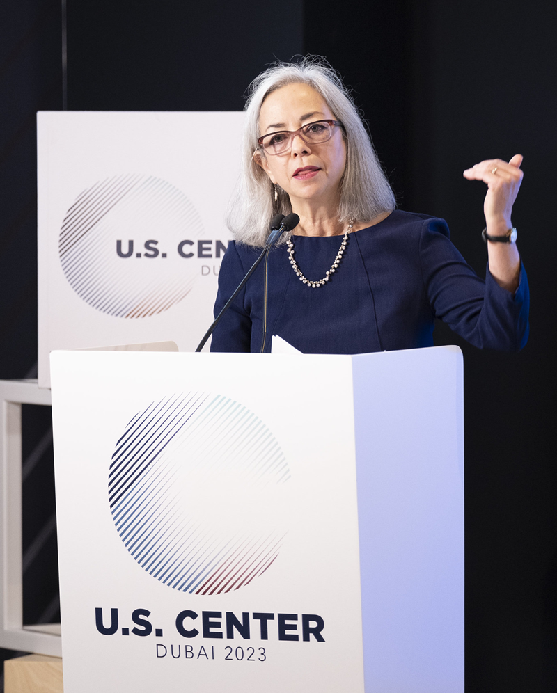 Thea Lee speaks at a podium labeled