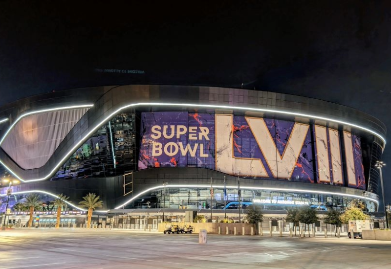 Exterior shot of a football stadium at night in Las Vegas, with an enormous sign reading 